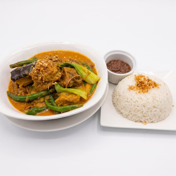 Filipino Kare-Kare, a peanut stew with meat and vegetables, served with rice and bagoong.